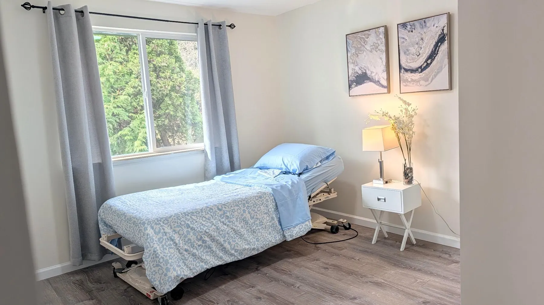 Comfortable resident bedroom with care bed at Rest Assured AFH